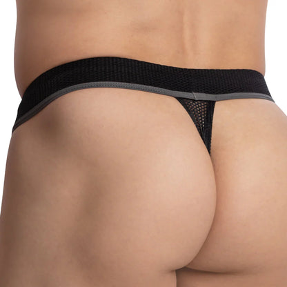 The image highlights the bold design of the Pistol Pete Half Naked Thong, featuring a daring black mesh fabric that offers exceptional comfort. It emphasizes the lower back and buttocks, showcasing the fit and texture of this adventurous underwear choice from Pistol Pete.
