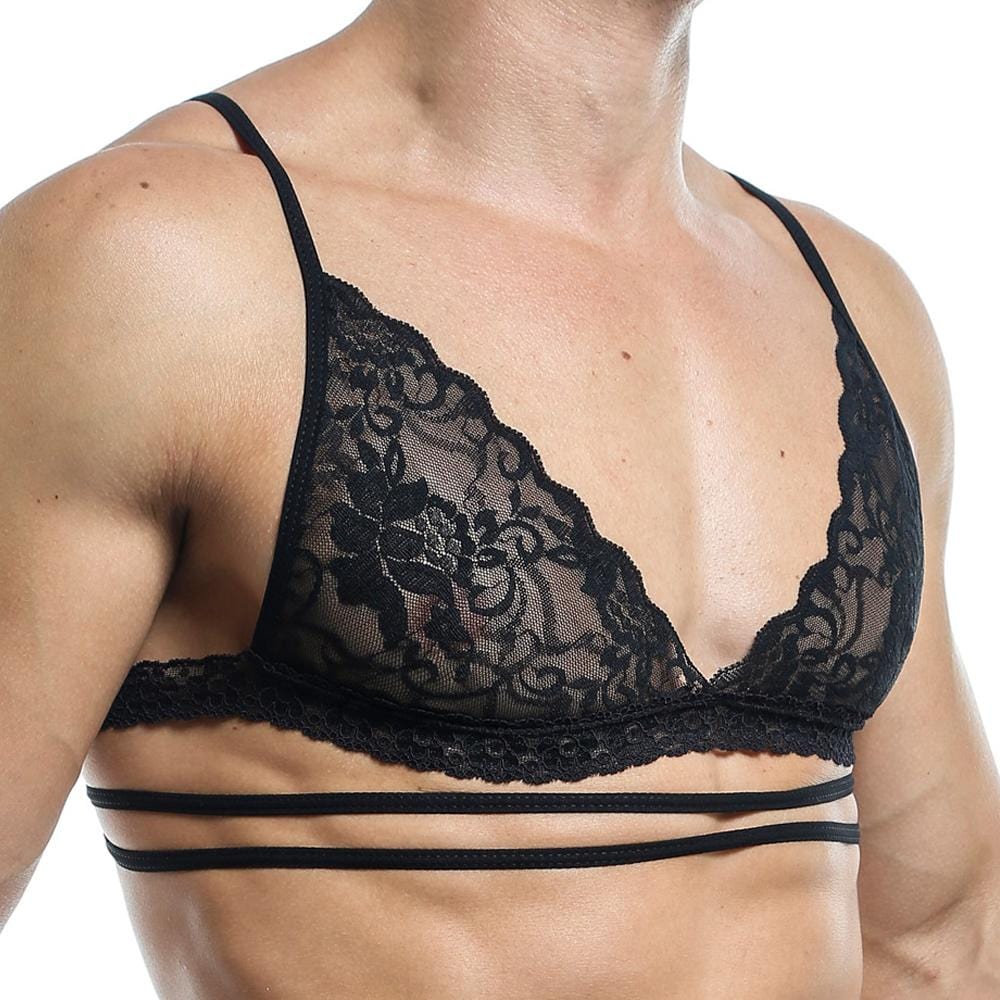 A person exudes allure in the Secret Male Tops black lace bralette by Secret Male, with thin straps and floral patterns. The multiple underbands enhance its design, boosting confidence while focusing on the intricately detailed upper body silhouette.