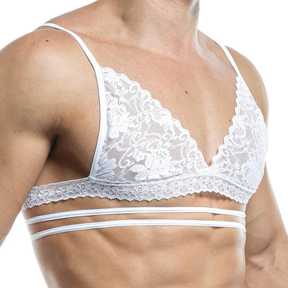 Wearing a Secret Male Tops white lace bralette with thin straps and floral patterns, featuring two extra torso bands, enhances the wearers seductive silhouette and complements their slightly tanned skin against a plain backdrop for a subtle confidence boost.