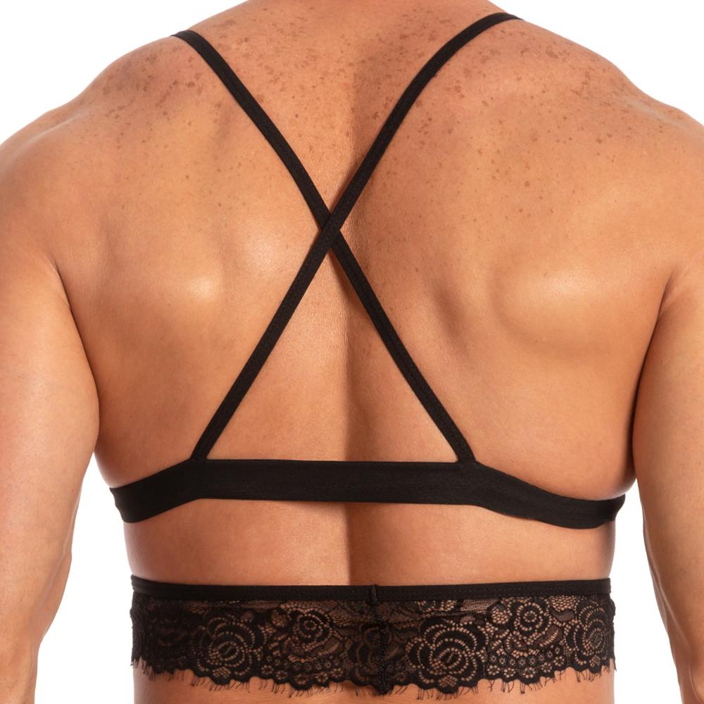 The image displays the back of an individual wearing the Secret Male SMA017 Justines Delight Bra. This black bra by Secret Male is crafted with spandex and adorned with delicate lace at the bottom, featuring elegantly crisscrossed straps across the upper back.