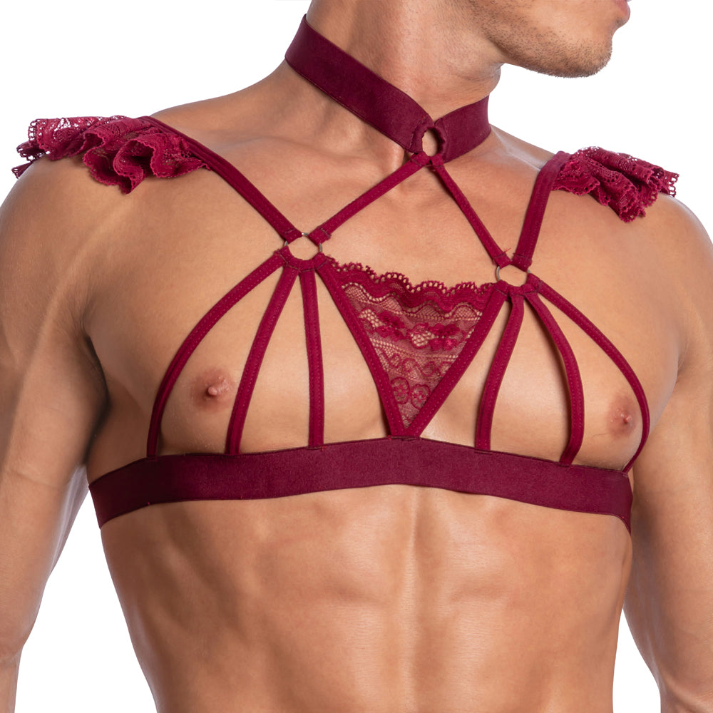 Someone is wearing the Secret Male Seductive Floral Top, featuring a seductive floral design with burgundy strappy lace harness, shoulder ruffles, sheer fabric, intricate straps, and an elegant choker that highlights their upper body.