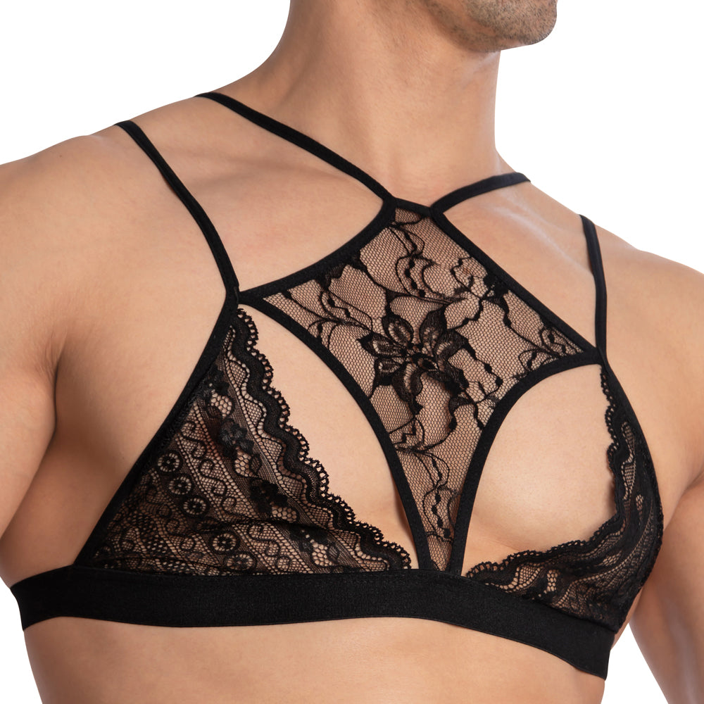 A person wearing the Secret Male Floral See Through Tops by Secret Male showcases their upper torso and shoulders with its intricate floral patterns, thin straps, and elegant black lace design.