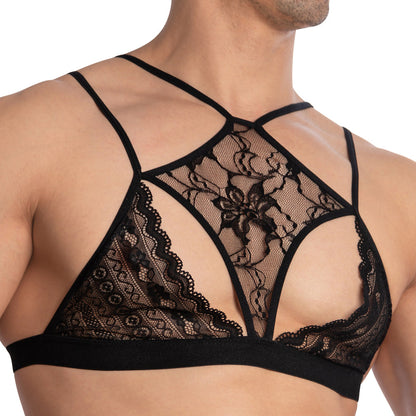 A person wearing the Secret Male Floral See Through Tops by Secret Male showcases their upper torso and shoulders with its intricate floral patterns, thin straps, and elegant black lace design.