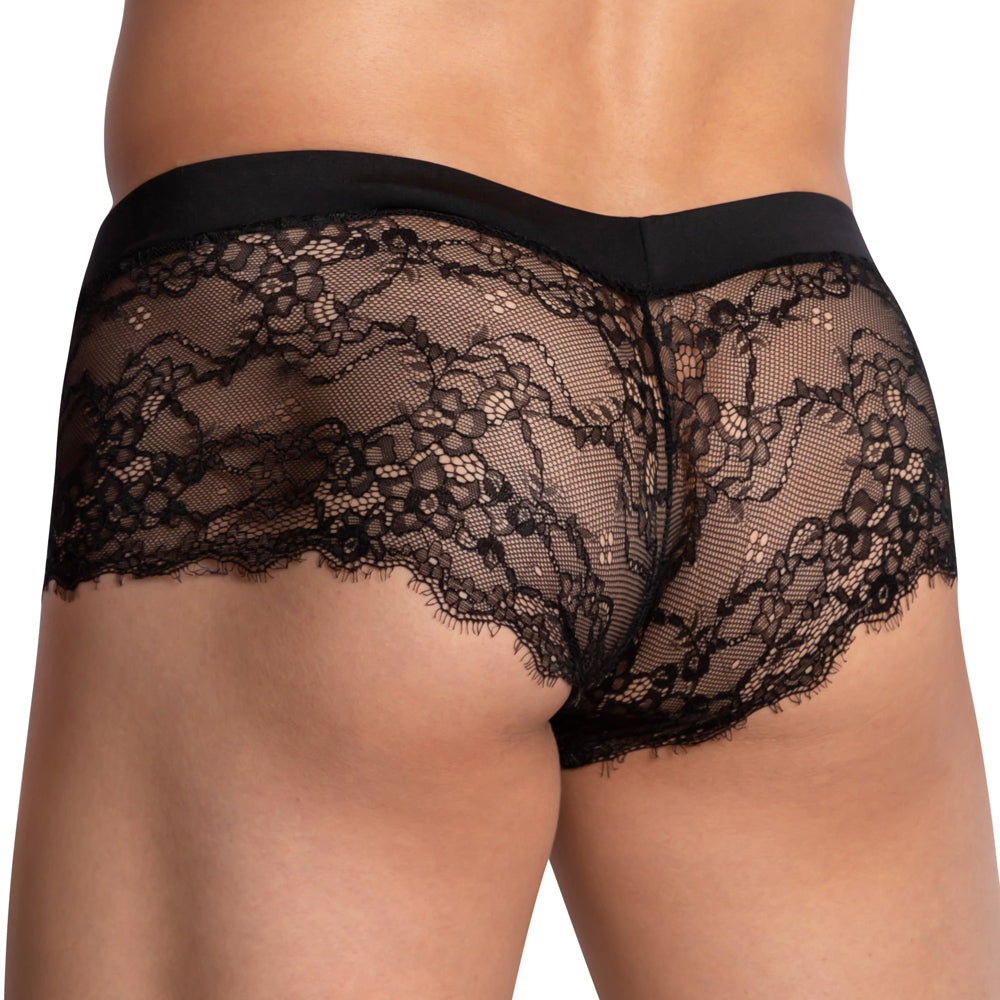 A close-up of Secret Males Sissy Mesh Bikinis reveals sheer black lace underwear with intricate floral patterns in comfortable stretch fabric, set against a simple black waistband on a plain white background.