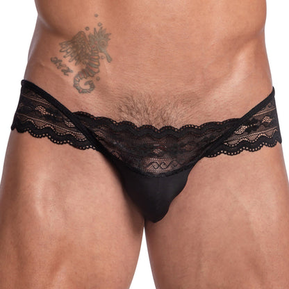 A person elegantly wearing the Secret Male Sissy Garter Bikini in black lace mens underwear, adorned with a seahorse tattoo on their stomach.