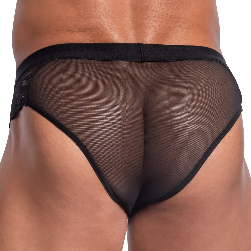 The image features a model wearing the Secret Male Steel Ring Sheer Bikini by Secret Male, viewed from behind. The black, sheer mesh fabric elegantly accentuates the garments design and smooth texture, subtly enhancing its allure.