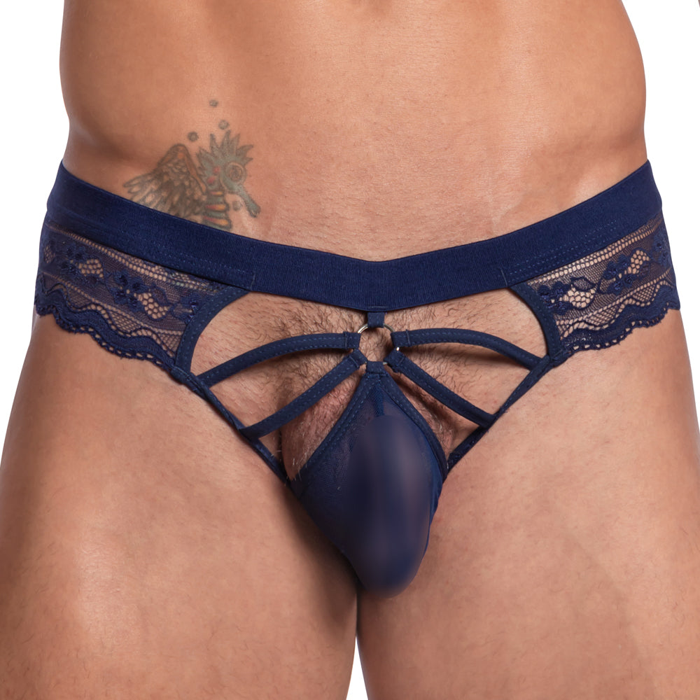 A person dressed in the Secret Male Steel Ring Sheer Bikini underwear, featuring strappy elements and dark blue sheer fabric, with a hip tattoo visible.