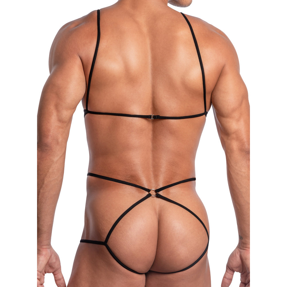 A person is seen from behind in the Secret Male SMV005 Designer See Through Body Suit, a minimalistic black piece made of polyamide. It features thin straps crossing the back and waist, forming a geometric pattern against a plain white background.