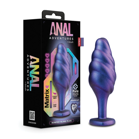 A colorful box labeled Blush Anal Adventures Matrix Bumped Bling Plug is next to a blue and purple swirled silicone plug from Blush Novelties, featuring StayPut technology, a tapered design with flared base, and a faux gem.