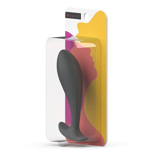The image showcases the Bfilled Basic Plug, a black silicone butt plug designed by Bfilled for anal pleasure. It features a soft finish and sleek, tapered head. The packaging combines clear plastic with colorful abstract shapes and a silhouette profile to highlight the products design.