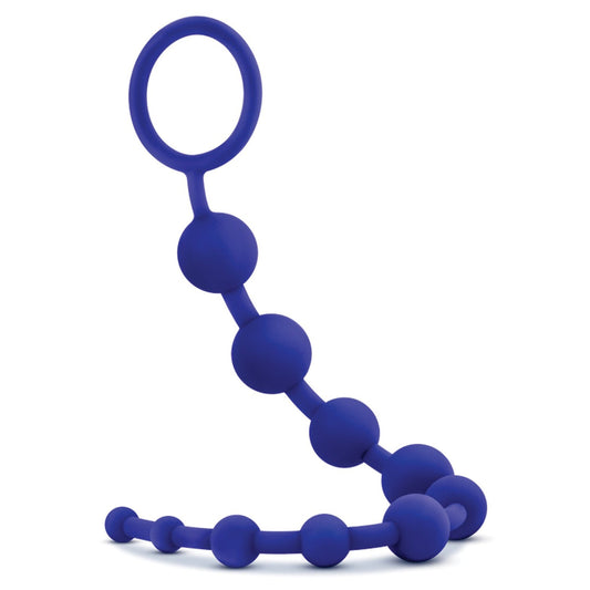 The Blush Luxe Silicone Beads by Blush Novelties are seamless blue anal beads made of body-safe silicone, featuring a curved, flexible strand with spherical beads that gradually increase in size and end with a ring handle for easy grip and control.