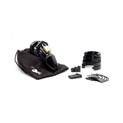 A black CB-6000 3 1/4 Cock Cage & Lock Set by CB-6000S features multiple pieces, rings, and spacers with a lock and set of keys on a black pouch. The dark accessories sharply contrast against the white background.