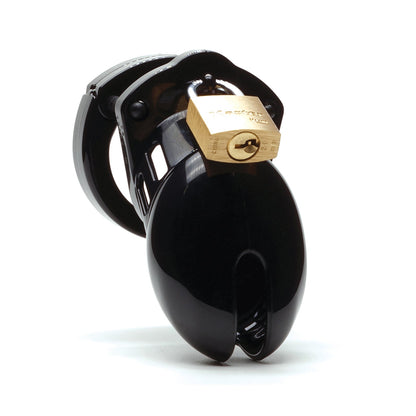 The CB-6000S 2 1/2 Cock Cage & Lock Set in black, made from medical-grade polycarbonate, features a shiny finish with a brass padlock securing its two main parts. The cylindrical device has a closed end and slots for ventilation.