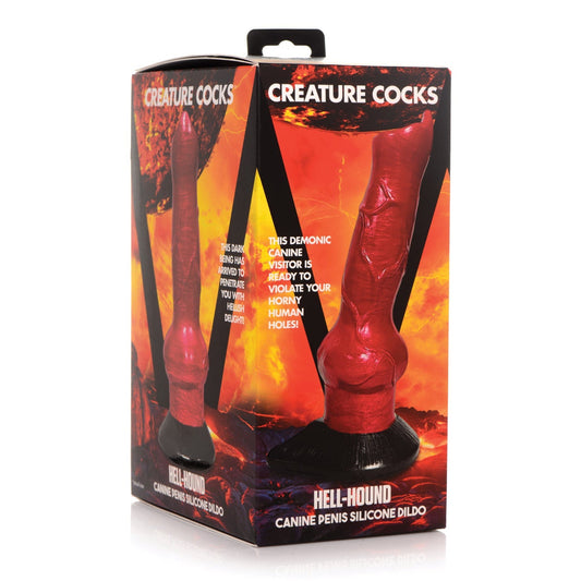 The packaging of the Creature Cocks Hell-Hound Canine Penis Silicone Dildo by Creature Cocks showcases a demonic canine with fiery, lava-like graphics. It includes a suction cup base for versatility and is harness-compatible for adventurous play.