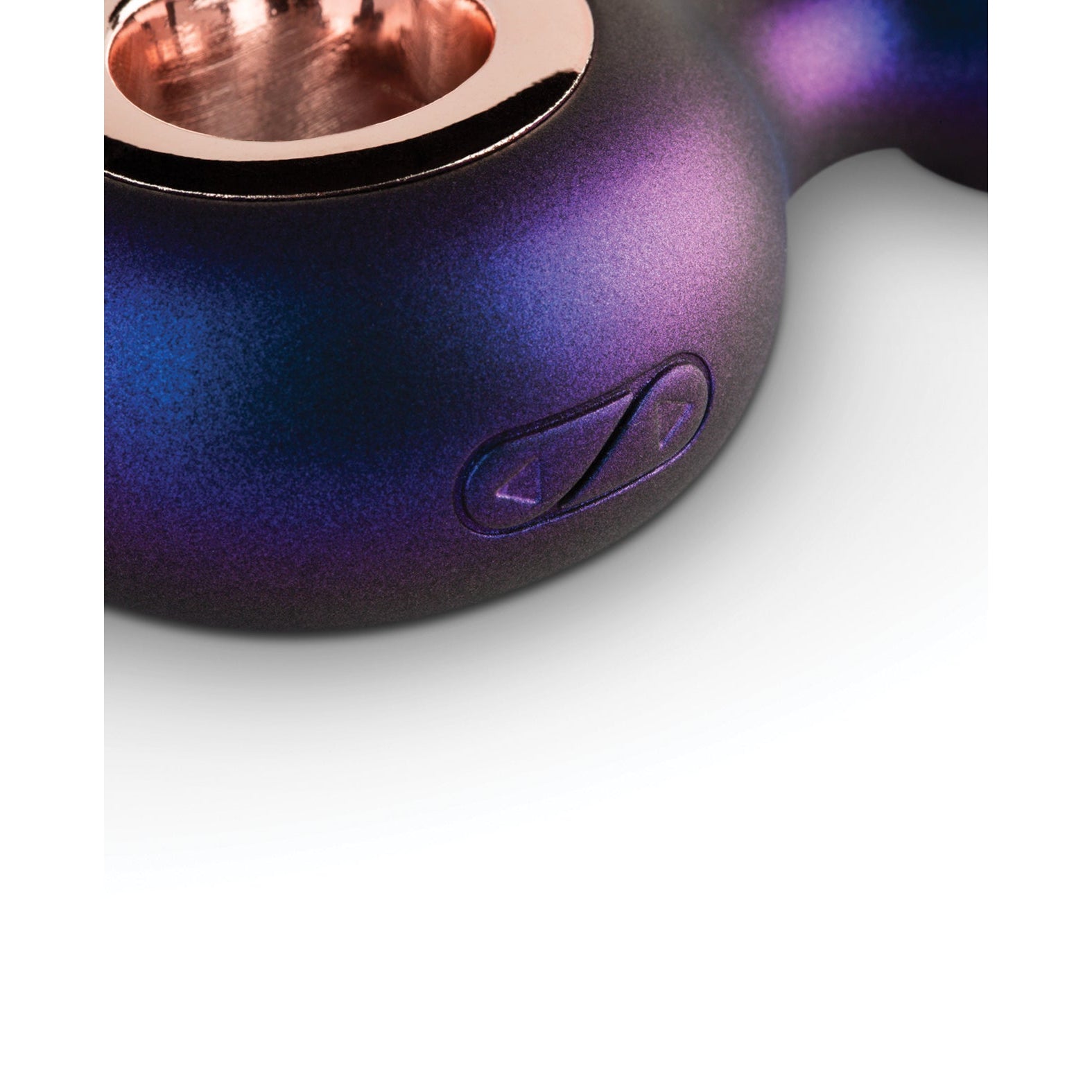 A close-up of the side of Huemans Deep Space Vibrating Anal Plug showcases its metallic, blue-purple-black gradient. It has a triangular button with arrow symbols for easy control and a shiny, reflective finish that enhances the silicone experience.