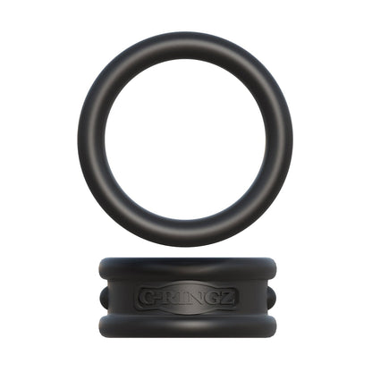 The Fantasy C-Ringz Max Width Silicone Cock Rings by Pipedream Products features a black silicone cock ring resting on a rectangular silicone block with embossed text, crafted from body-safe material. The ring and block are separate pieces, with grooves and raised lettering, isolated on a white background.