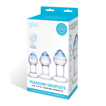 The Gläs Pleasure Droplets Anal Training Kit includes a trio of stunning handblown glass butt plugs with gradient blue tints in sizes 3.25, 3.5, and 4. The packaging highlights these features and includes a luxury satin storage bag, reflecting its exquisite design.