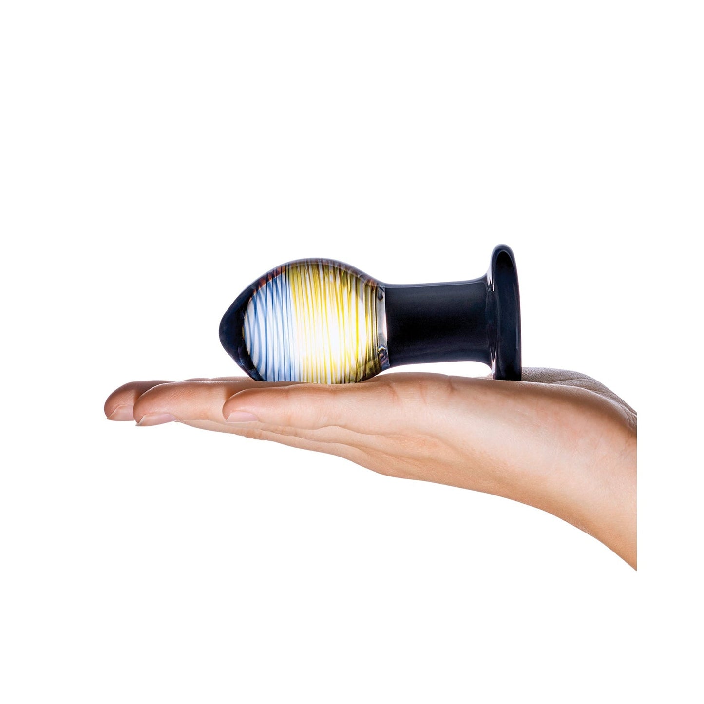 A hand displays the Gläs Galileo Glass Butt Plug, a multicolored piece with blue and yellow hues and a flared base, made from smooth Pyrex glass, contrasting with the white background.