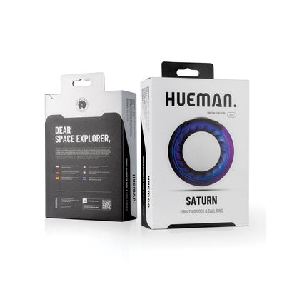 Two boxes of the Hueman Saturn Vibrating Cock & Ball Ring are on display. The front box highlights its circular design with a blue and purple color scheme, while the back provides instructions for intergalactic fun. Explore 10 vibration modes by Hueman for out-of-this-world adventures.