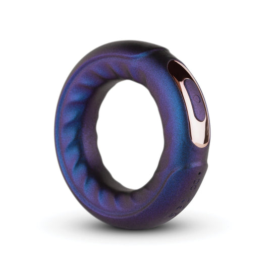 The Hueman Saturn Vibrating Cock & Ball Ring features a dark metallic blue, ring-shaped design with a smooth, textured surface. A rose gold accent surrounds the button, activating 10 vibrating modes for intergalactic fun. Inner grooves enhance pleasure in this stylish piece by Hueman.