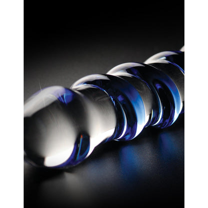 The Icicles No. 5 Hand Blown Glass Massager by Pipedream features a twisted, spiral design with blue swirls on its transparent surface, reflecting light to create a soft glow against the dark background.