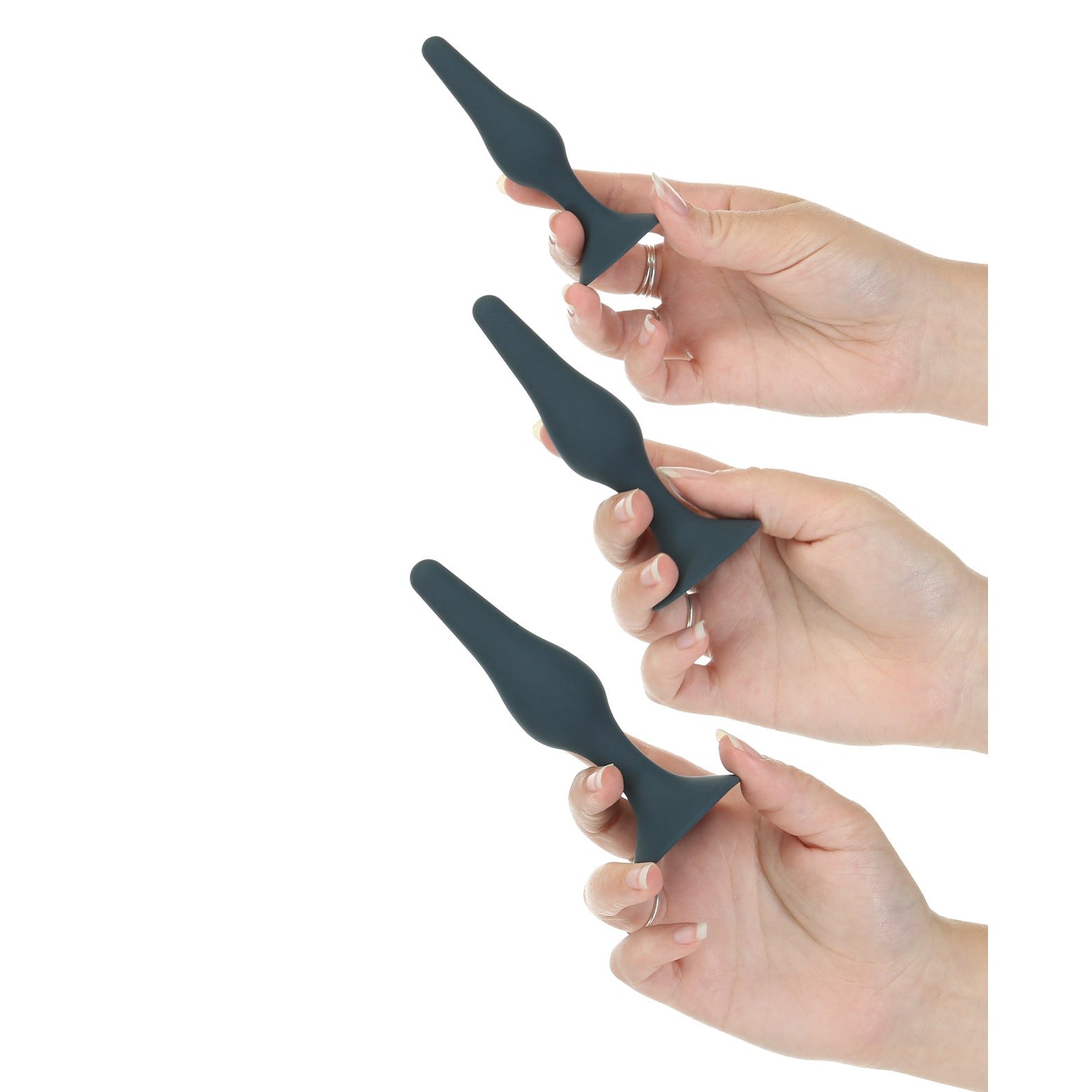 Three hands showcase the Lux Active Equip Silicone Anal Training Kit from LUX, featuring dark green silicone plugs of varying sizes with a smooth, tapered design perfect for easy application of lubricant against a white background.