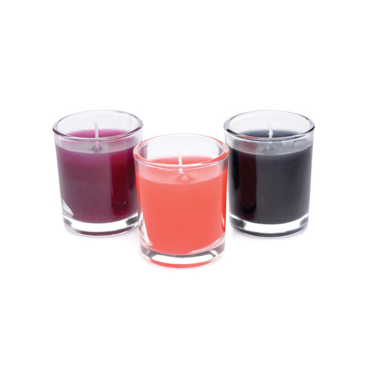 The Master Series Flame Drippers Candle Set features three small candles in vibrant purple, pink, and black glass holders arranged in a row. Made with low melting point wax, these candles are perfect for candle play.