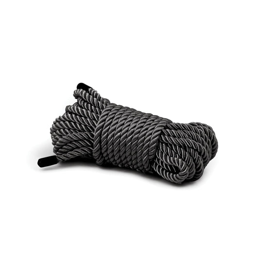 A neatly arranged coiled bundle of thick gray Bondage Couture Rope by Bondage Couture, made from high-quality synthetic material, is displayed on a white background, with black ends visible on each side.