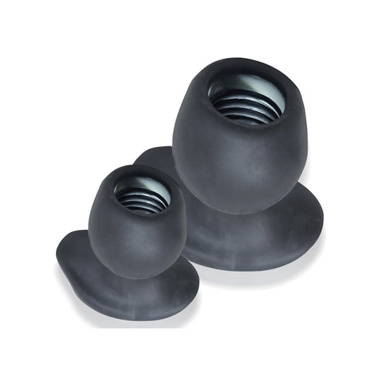 Two Oxballs Morphhole 2 Gaper Plugs in black rubber, different sizes, are displayed on a white background. Each has a flared base, rounded top, and visible thread inside to protect floors from scratches.