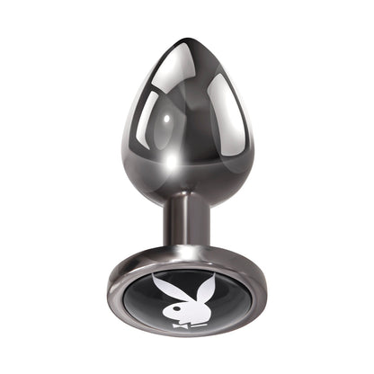 The Playboy Tux Butt Plug by Playboy features a sleek, bulbous design made from body-safe aluminum alloy. It has a circular base with a white rabbit silhouette on a black background, ideal for enhancing anal play.