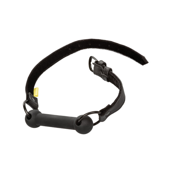 The California Exotic Novelties Boundless Bar Gag features a sleek black and gray vegan leather strap, a cylindrical rubber bar, metal rings, and a Velcro fastening for easy adjustment, making it an intriguing adult toy addition.