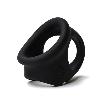 The Sport Fucker Cock Chute by Sport Fucker is a black silicone ring with a sleek, modern design and features a wide base, slight curve, smooth edges, and an embossed logo. It stands upright against a plain white background.