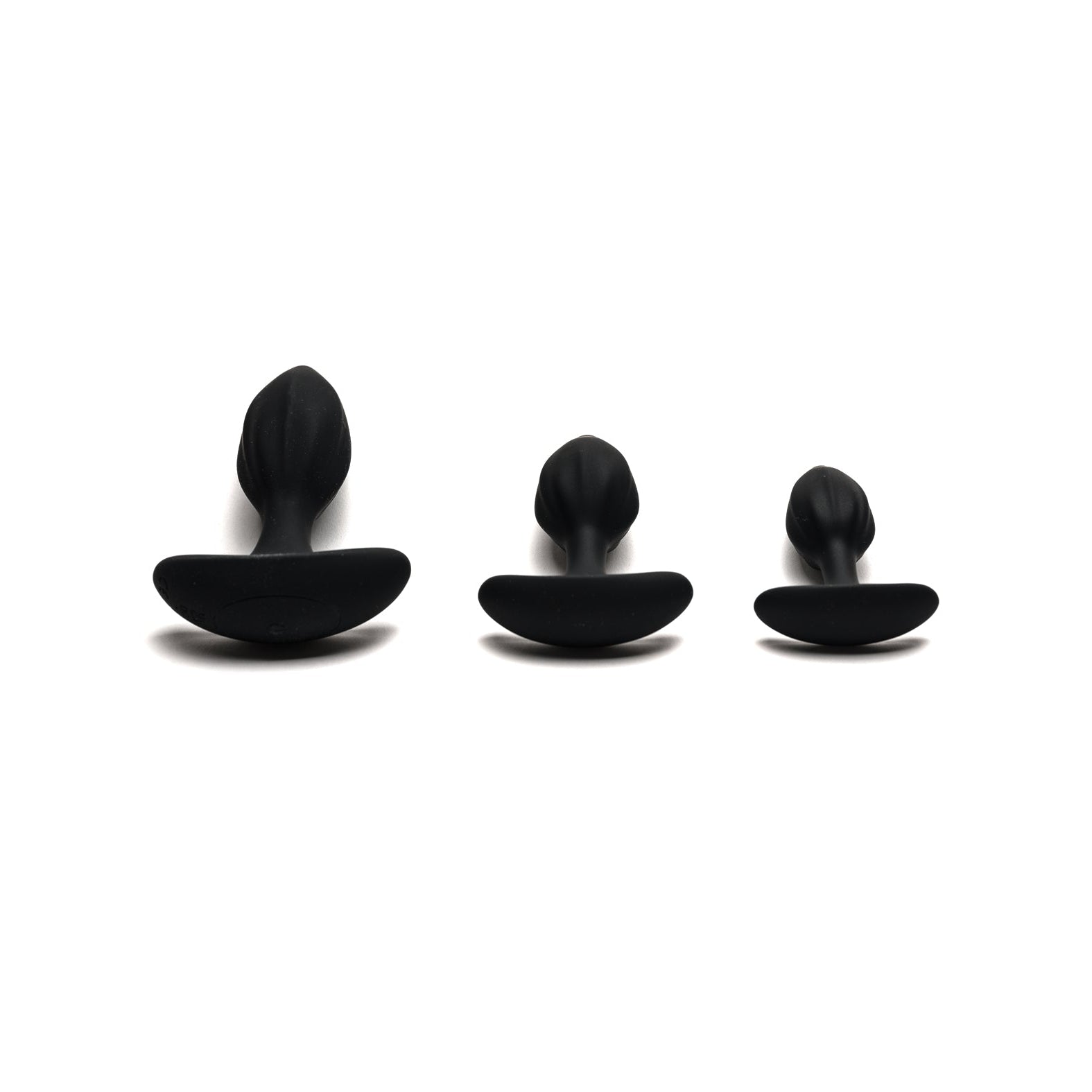 Three black plug-shaped objects, part of the Sport Fucker MotoVibe Plug N Play Kit, are lined up on a white background. Each has a rounded top and flat base, designed to enhance your booty workout with precision and comfort.
