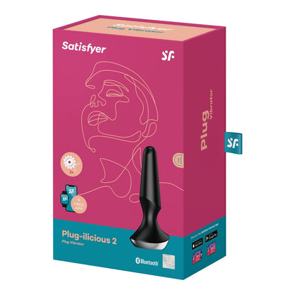The image displays the Satisfyer Plug-ilicious 2s packaging, featuring a pink box with an outlined face design, a product image, and info on its app-controlled Bluetooth connectivity.