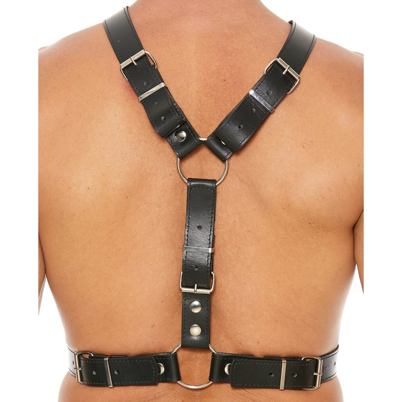 A person is seen from the back wearing the Shots Uomo Mens Harness with Metal Bit by Shots Ouch. The black harness features metal rings and adjustable straps, forming an X shape across the shoulders and fastening securely around the chest, showcasing intricate bondage accessory design.