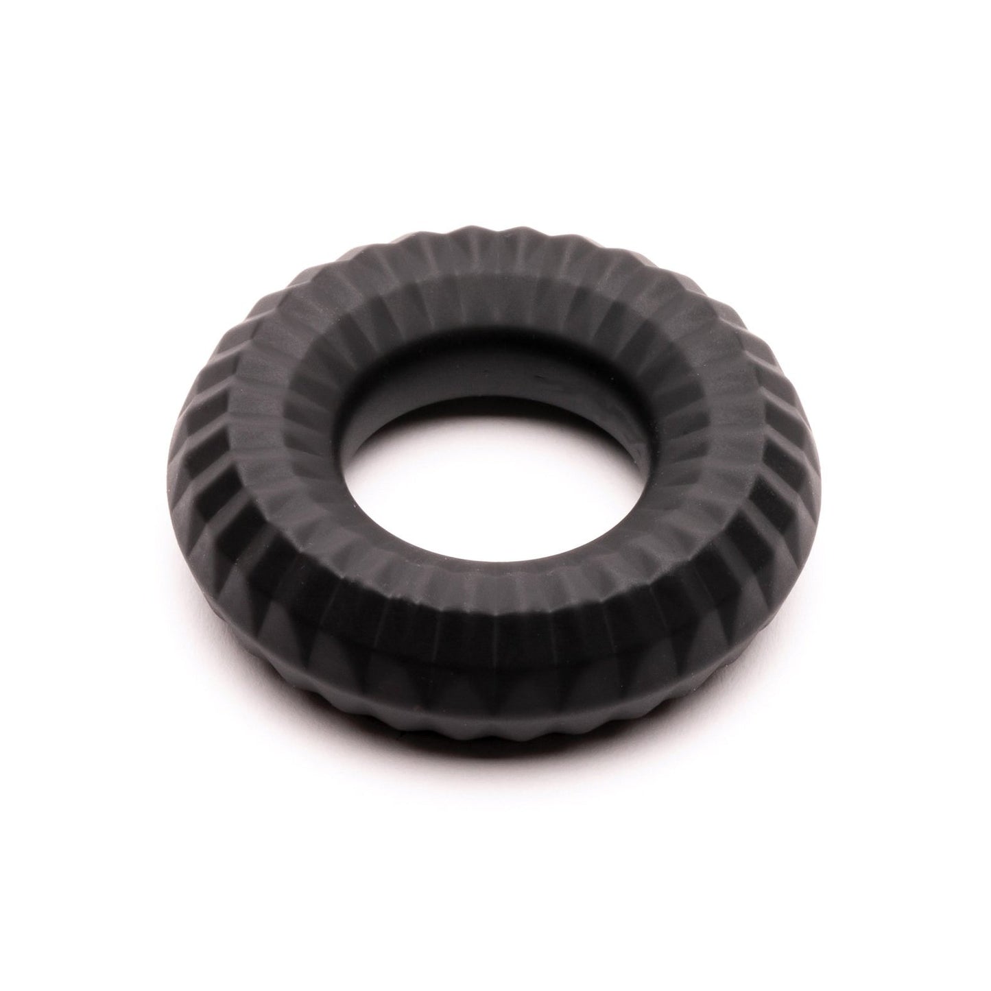 The Sport Fucker Nitro Ring from Sport Fucker is black and round with a textured, grooved surface, resembling a small tire or industrial component. It appears solid and evenly molded against a plain white background.