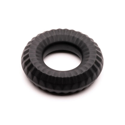 The Sport Fucker Nitro Ring from Sport Fucker is black and round with a textured, grooved surface, resembling a small tire or industrial component. It appears solid and evenly molded against a plain white background.