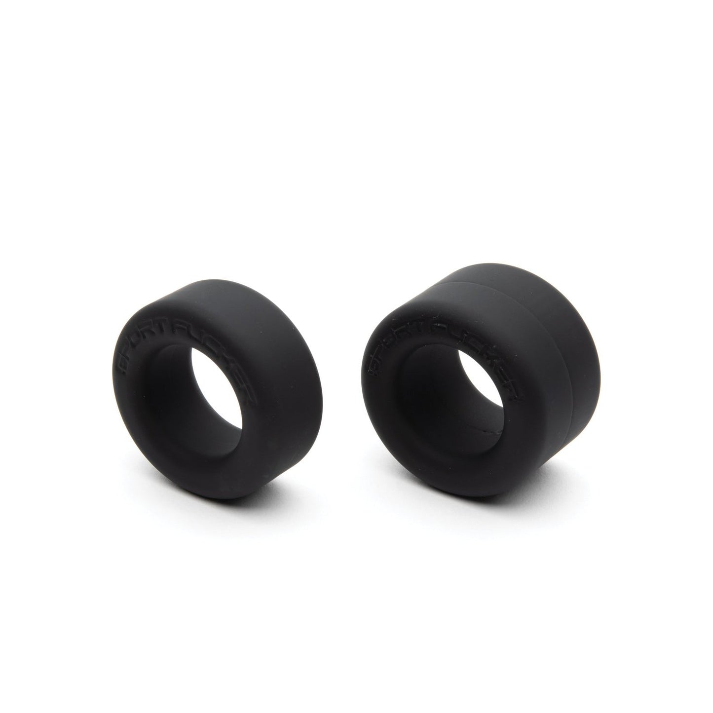 The Sport Fucker Nutt Job Rings, by Sport Fucker, are two black rubber spacers of varying sizes against a white background. Made from stretchy silicone, these spacers are cylindrical with central openings.