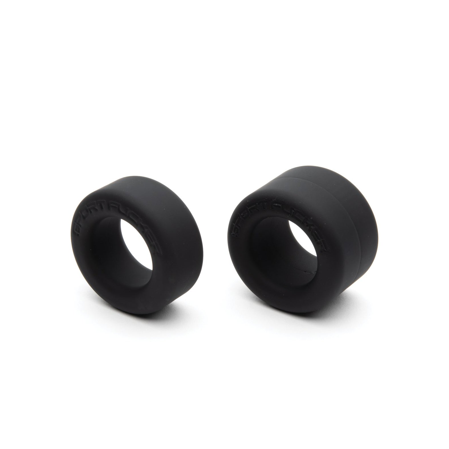 The Sport Fucker Nutt Job Rings, by Sport Fucker, are two black rubber spacers of varying sizes against a white background. Made from stretchy silicone, these spacers are cylindrical with central openings.