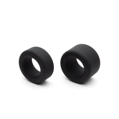 The Sport Fucker Nutt Job Rings, by Sport Fucker, are two black rubber spacers of varying sizes against a white background. Made from stretchy silicone, these spacers are cylindrical with central openings.