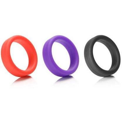Three Tantus 1.5 Supersoft C Rings in red, purple, and black are displayed side by side on a reflective white surface, highlighting their vibrant allure and promise of comfort.