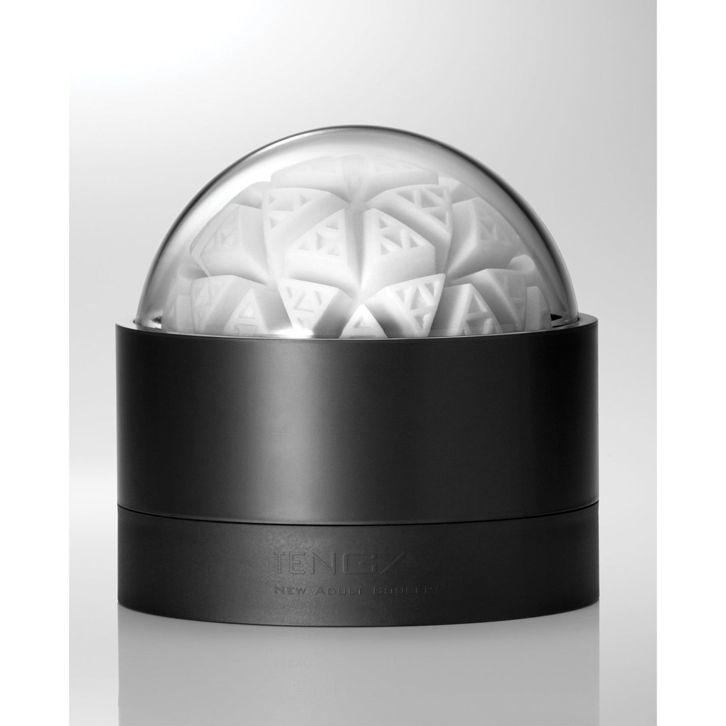 The Tenga GEO Glacier - White, by Tenga, features a futuristic black container with a stretchable material. It has a transparent dome lid that reveals an intricate geometric pattern of triangular shapes layered spherically on a white background, emphasizing its reusable design.