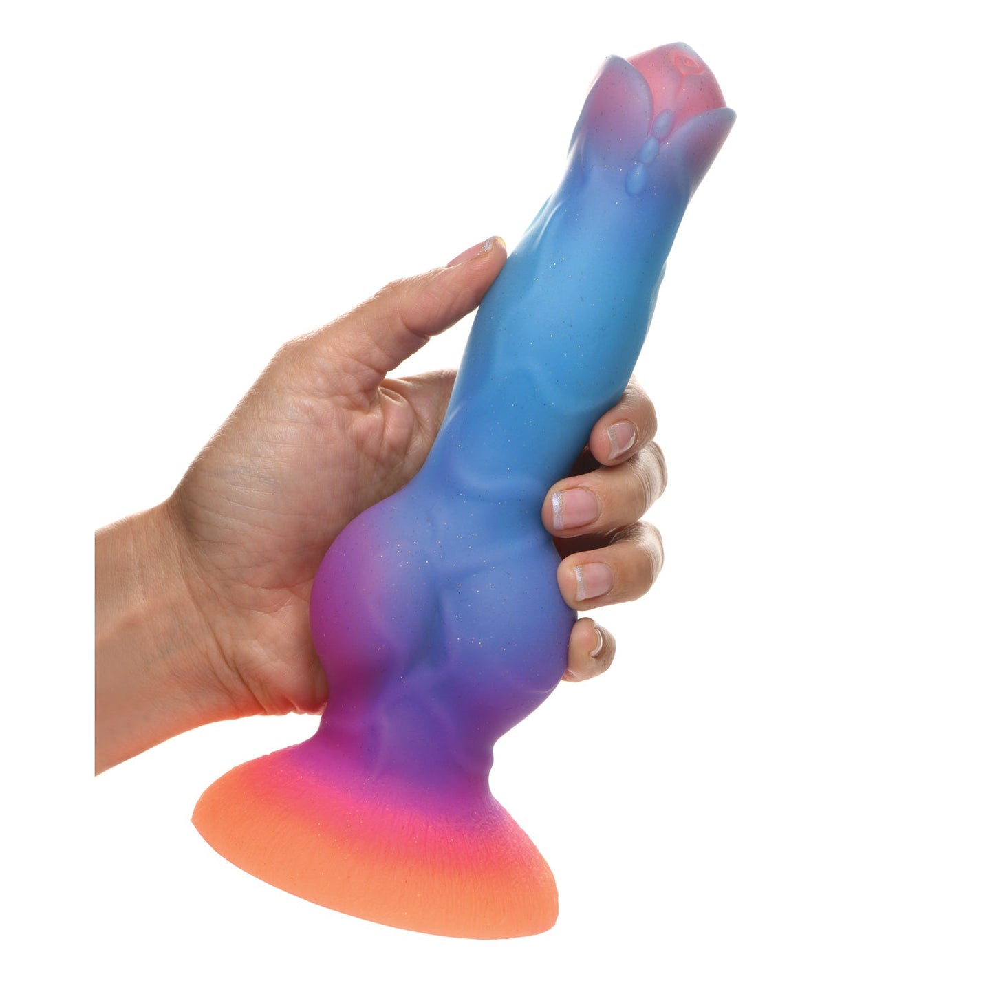 A hand holds the Creature Cocks Space Cock, a premium silicone alien dildo that glows in the dark. It features a blue-to-orange gradient, textured surface, and flared base, perfect for fantasy roleplay.