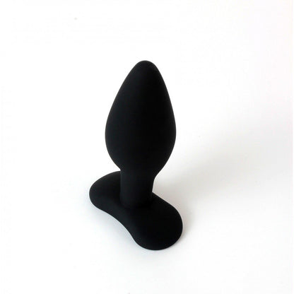 The Pipedream Anal Fantasy Collection 100% Silicone Small Butt Plug, featuring a sleek black design with a tapered shape and flared base, elegantly stands on a pristine white background.