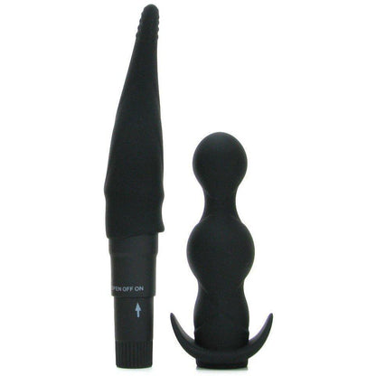 In the Pipedream Anal Fantasy Collection Anal Adventure Kit, two black silicone anal toys stand upright against a white background: on the left, a tapered unisex vibrator with ribbed texture and an on/off switch at the base; on the right, a beaded mini-vibe with a curved base for easy handling.
