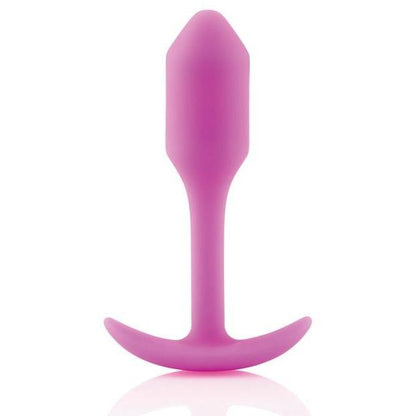 The B-Vibe Snug Butt Plug 1 by b-vibe, made from body-safe pink silicone, features a smooth tapered shape and a T-shaped base, displayed on a white background.