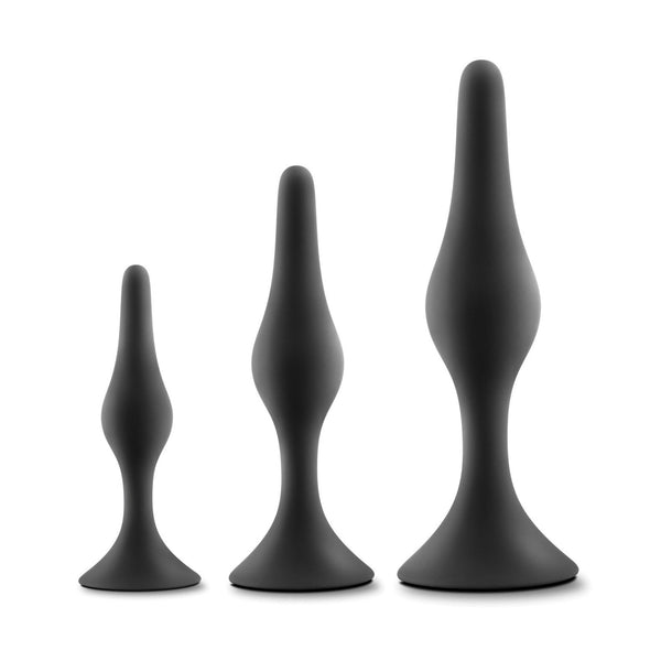 The Blush Luxe Beginner Plug Kit by Blush Novelties features three black silicone plugs in ascending sizes on a white background. Each plug has a smooth, tapered design made from body-safe silicone, perfect for beginners exploring new sensations.