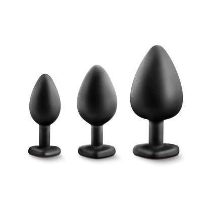 Three Blush Luxe Bling Plugs with Gems by Swiss Navy are lined up in a row against a white background. The plugs, crafted from body-safe black silicone, feature a tapered shape and flat base. Ideal for anal training enthusiasts looking for comfort and progression.