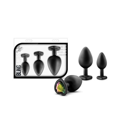 The Blush Luxe Bling Plugs with Gems by Swiss Navy are a set of three black silicone plugs adorned with faux gemstones at the base. Labeled Bling Plugs, they come in various sizes and are packaged for anal training, with the body-safe plugs displayed outside the box.