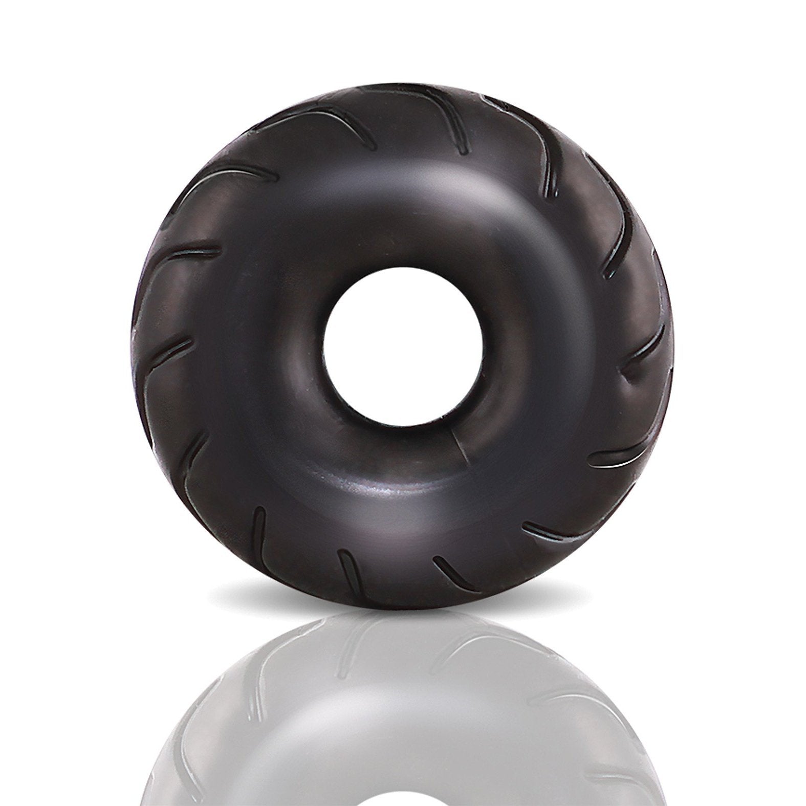 A glossy, black, donut-shaped object made from stretchy X5Plus material with subtle grooves and a central hole resembles the Blush Performance Truck Tire Cock Ring by Blush Novelties. Its shown on a plain white background with a soft reflection beneath.